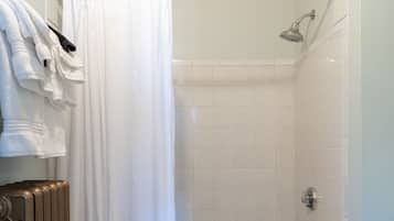 A bathroom with a shower, a bathtub, and a radiator.