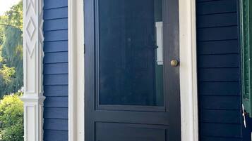 A dark blue door with a white frame, a welcome mat, and a small horse decoration on the porch.