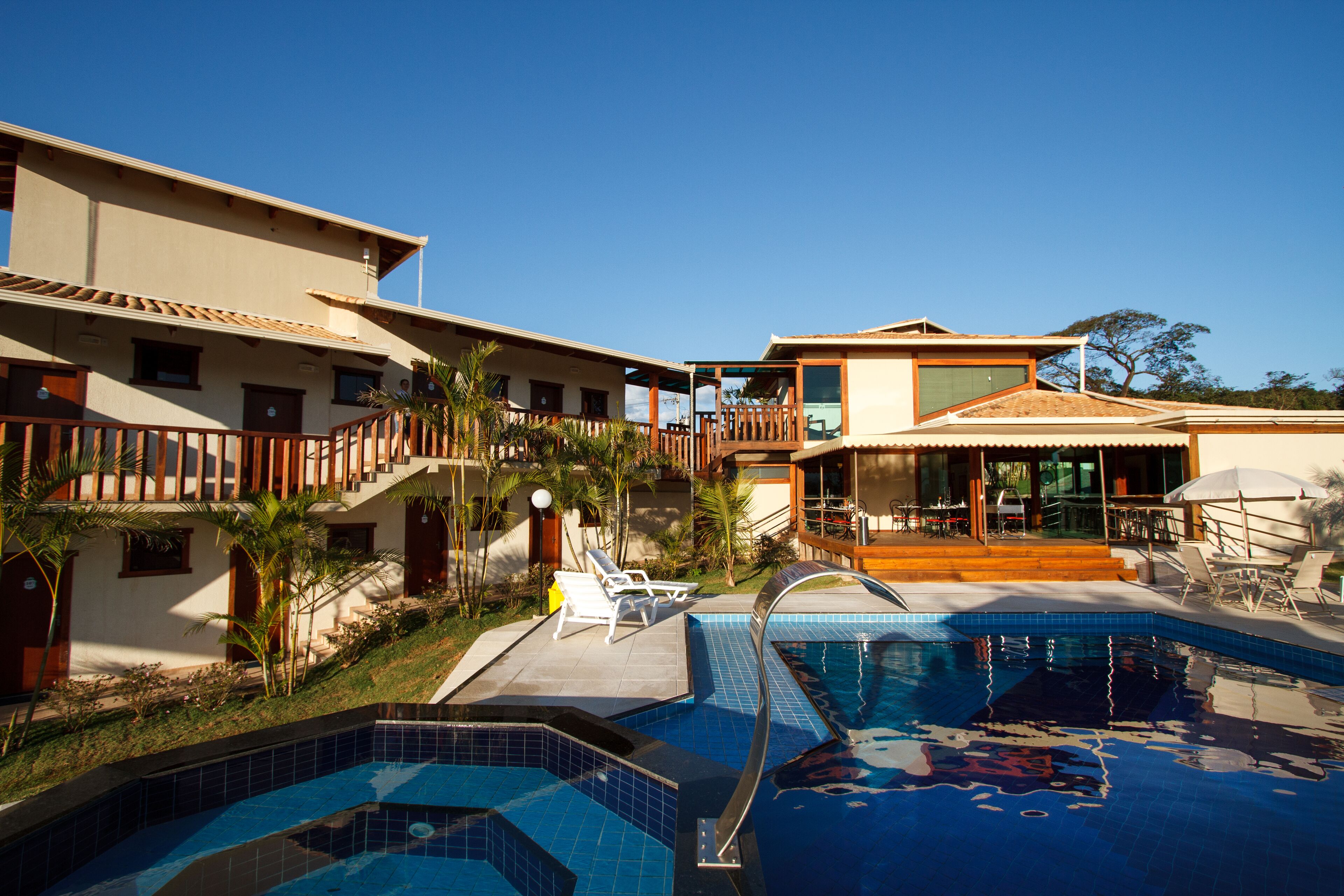 A resort with a swimming pool, multiple buildings, and outdoor seating areas.