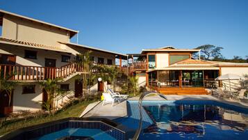 A resort with a swimming pool, multiple buildings, and outdoor seating areas.