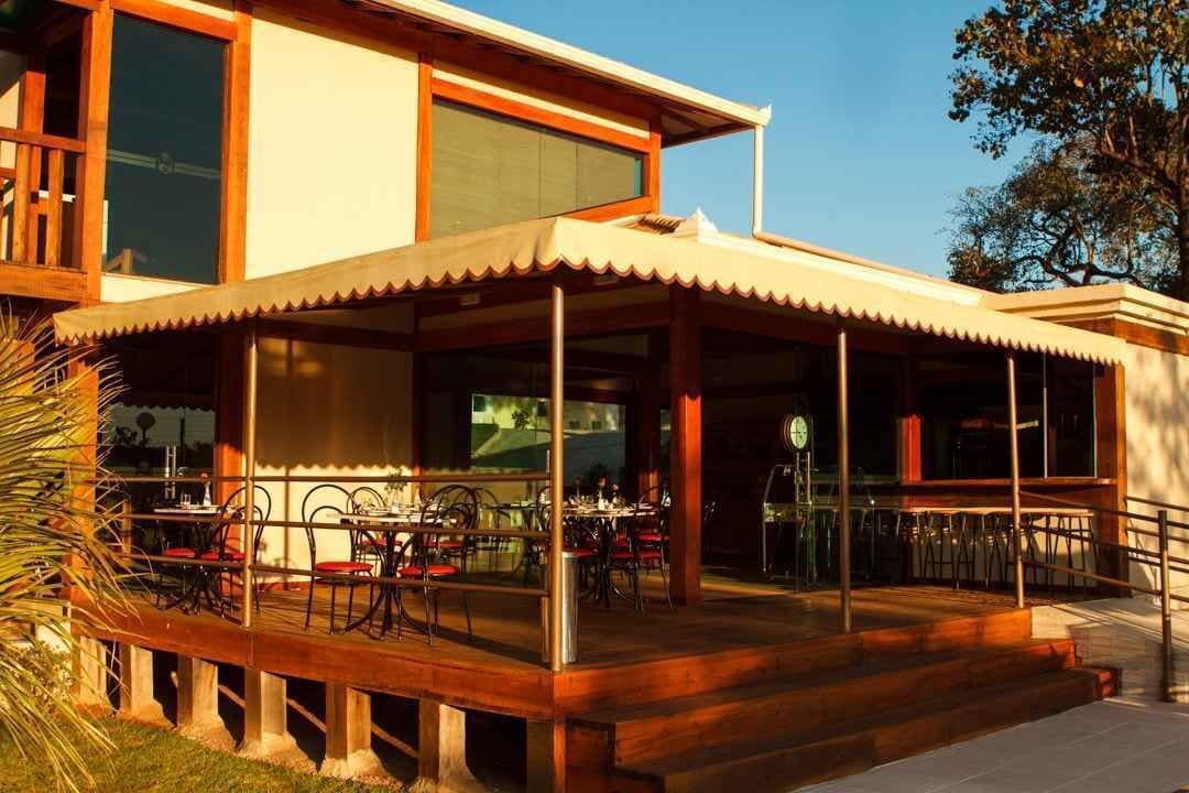 A modern two-story building with a covered outdoor dining area and a staircase leading to the entrance.
