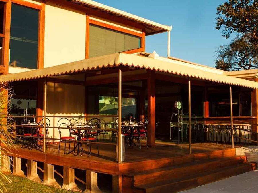 A modern two-story building with a covered outdoor dining area and a staircase leading to the entrance.