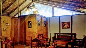 A rustic wooden interior with a high ceiling, wooden walls, and a bench. - Guacamayo Bed & Breakfast (Máncora)