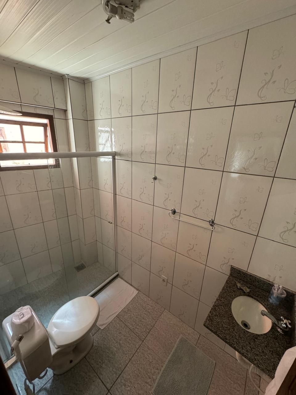 Een badkamer met toilet, wastafel en douchehoek.