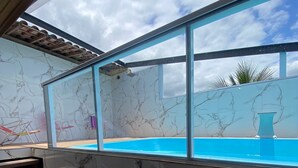 A modern interior with a marble staircase leading to a glass-enclosed pool area. - Pousada Toca do Cambú (Angra dos Reis)