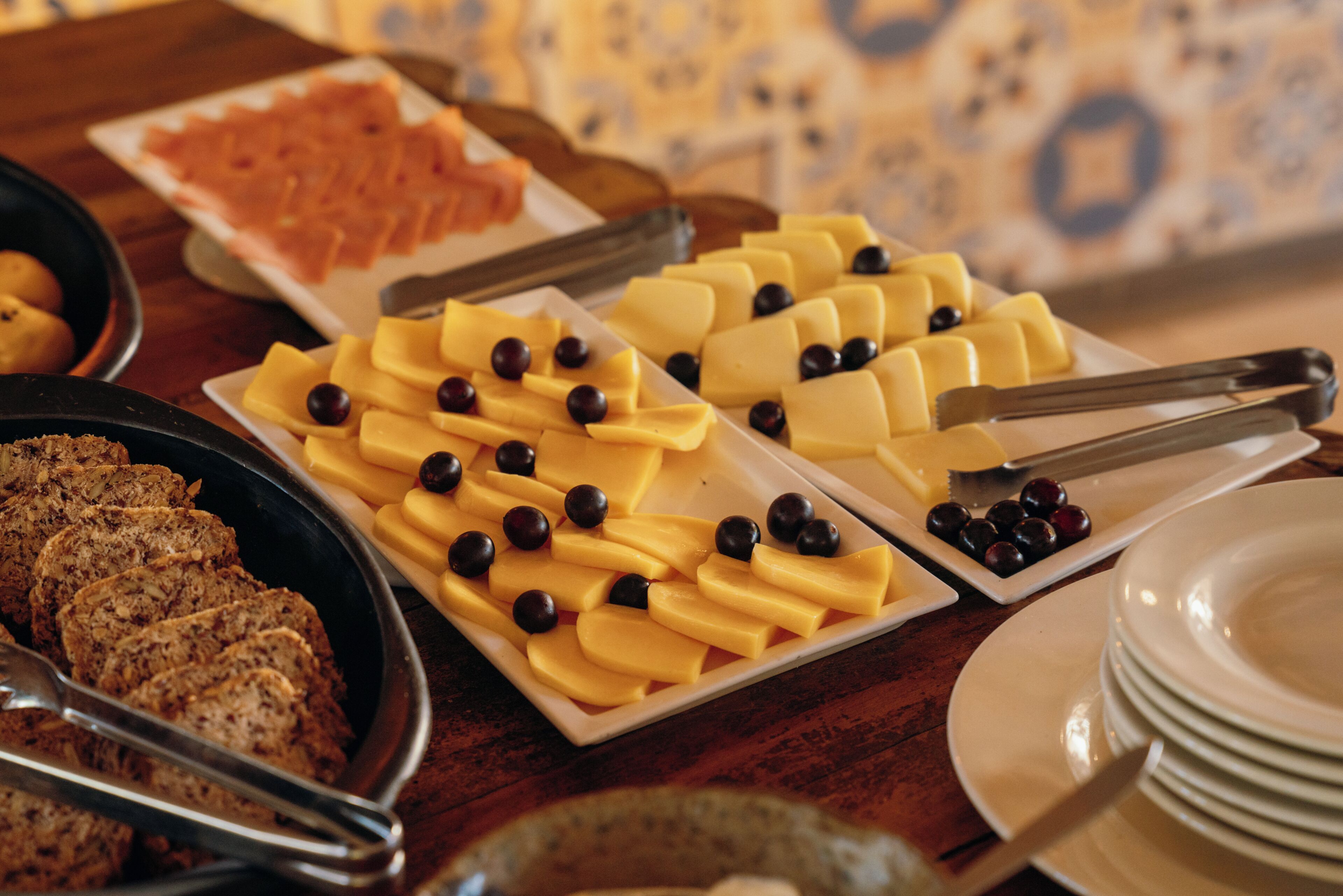 A buffet with various food items including cheese, olives, and bread.