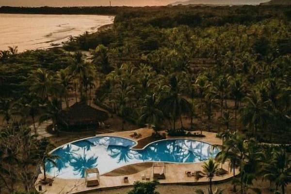 Una piscina al aire libre, sillones reclinables de piscina
