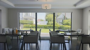 Ein moderner Essbereich mit großem Fenster, dunklem Holzboden und zeitgemäßer Einrichtung.
