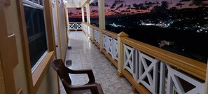 A balcony with a view of a sunset over a cityscape. - Sunburst Apartments (Arnos Vale)