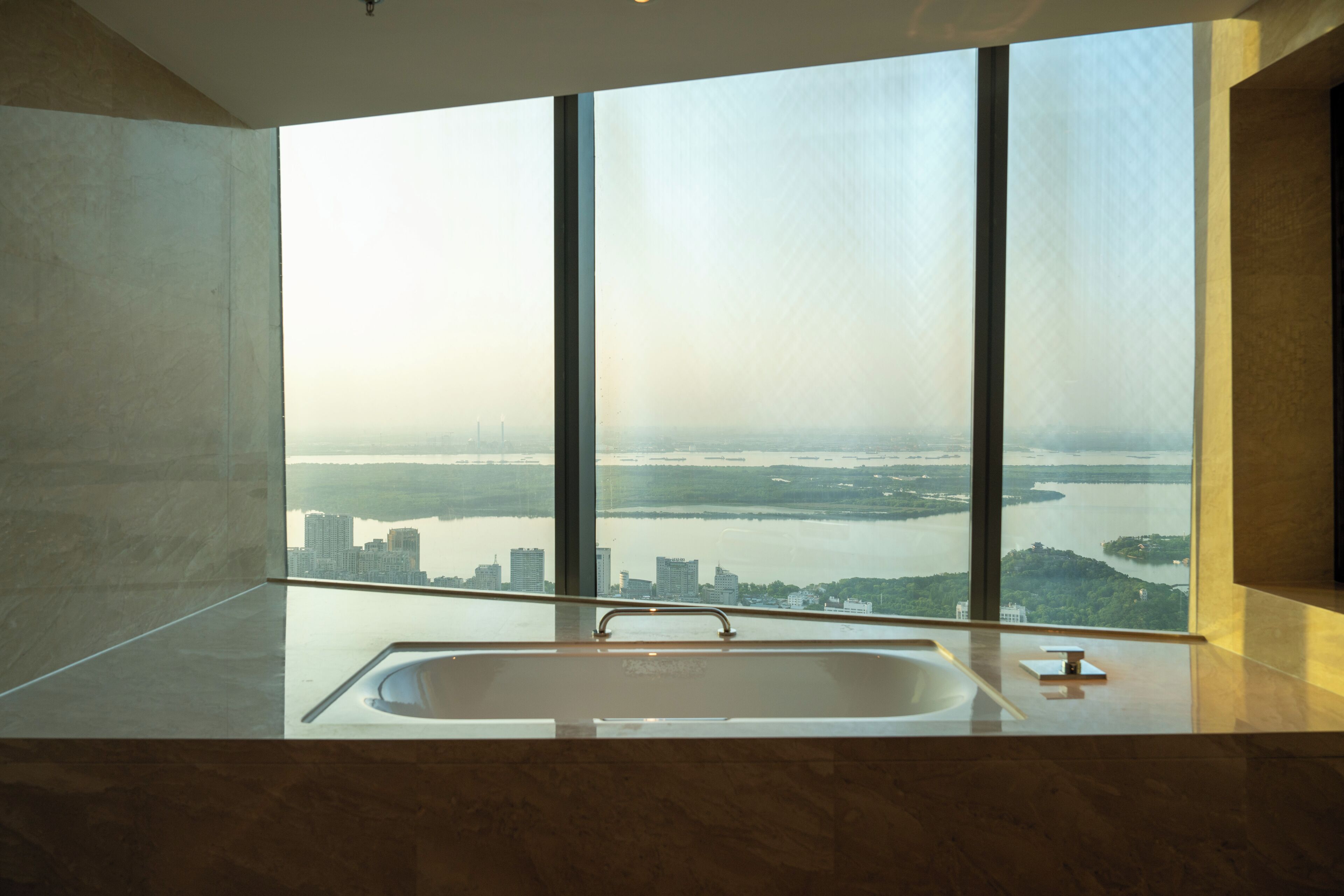 A modern bathroom with a large window, a sink, and a mirror.