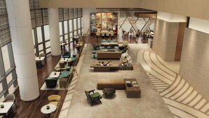 A spacious lobby with seating areas, a central art installation, and a staircase. - Zhenjiang Marriott Hotel (Zhenjiang)