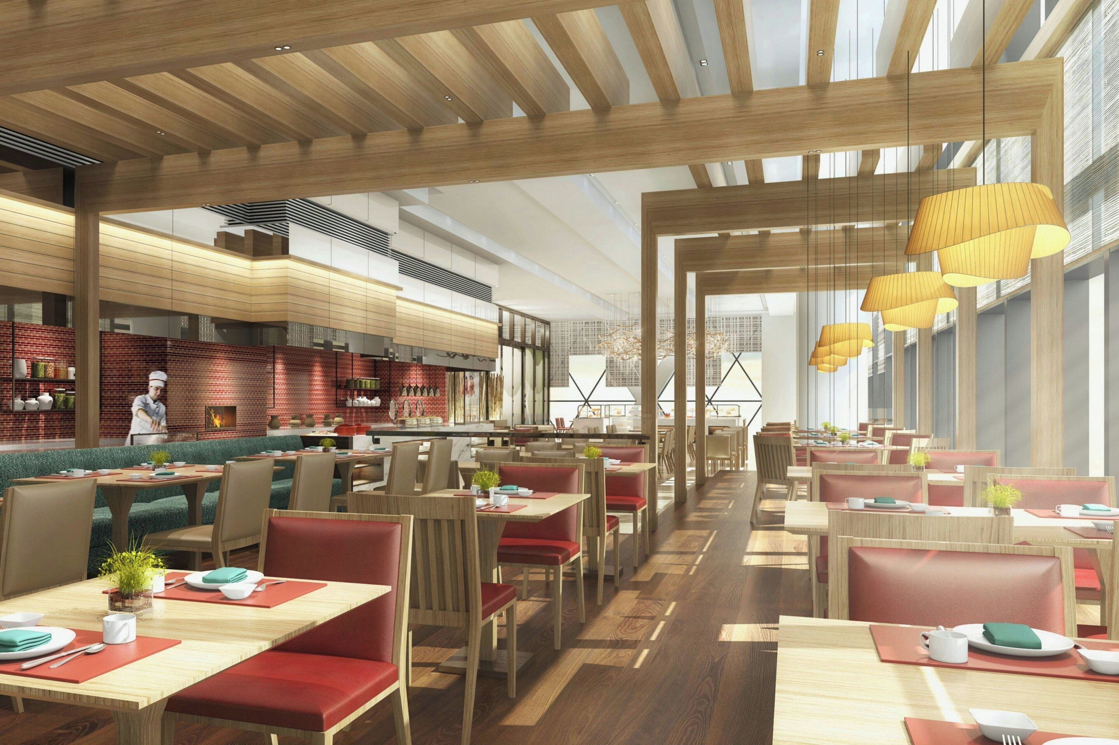 A modern restaurant interior with wooden beams, red cushioned booths, and hanging pendant lights.