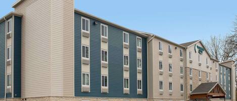 Un hôtel à plusieurs étages, doté d’une façade en pierre et d’une combinaison de murs extérieurs de couleur beige et bleue.