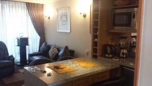 A compact living space with a kitchen area, a dining table, and a sofa.