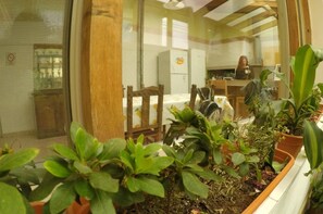 A dining area with a table, chairs, and potted plants. - As Nancy Ushuaia B&B (Ushuaia)