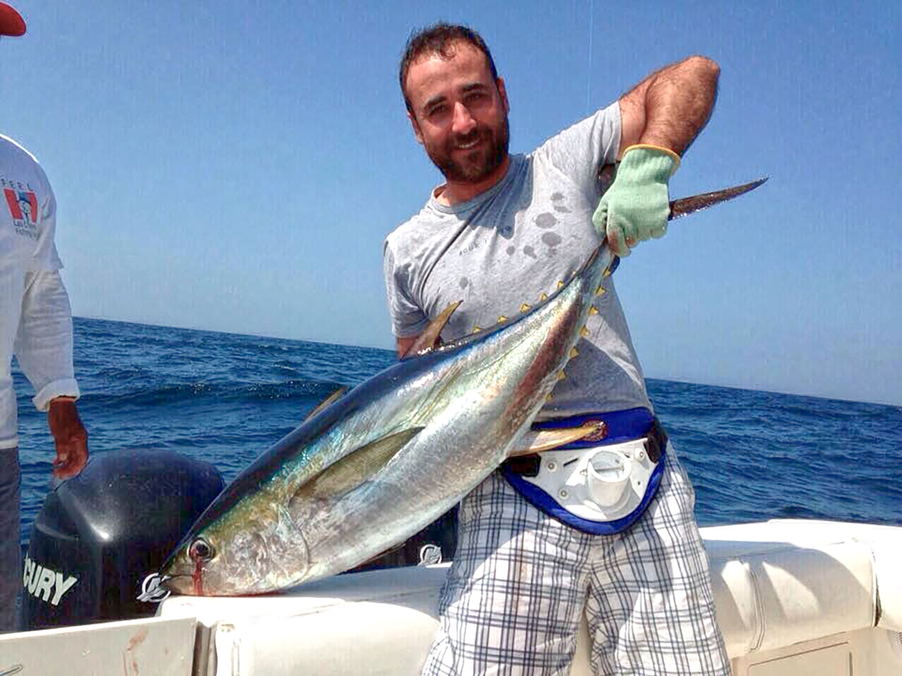 A person holding a large fish on a boat.