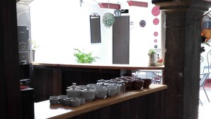 A cafe with a wooden counter, a tiled floor, and a view of the street outside.