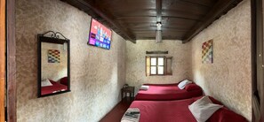 A room with two beds, a TV mounted on the wall, and a window. - Hotel Cristal (Antigua Guatemala)