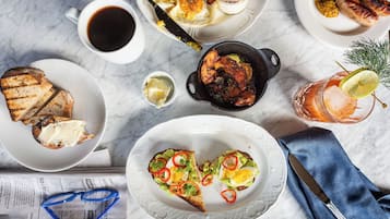 A breakfast setting with toast, eggs, and a drink on a marble table.
