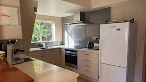 Una cocina moderna con horno empotrado, refrigerador y ventana que proporciona luz natural.