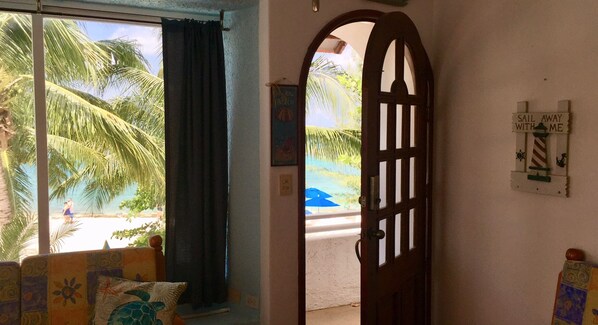 Una habitación con vistas a la playa, una puerta de madera y un cartel en la pared.