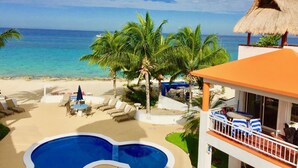 Un resort con piscina, lettini e vista sull'oceano.