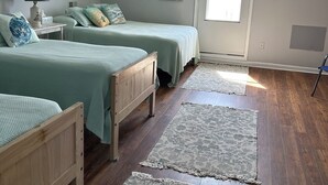 A bedroom with two beds, a nightstand, a lamp, a window, and a door. - Soundfront home
3 Bedrooms
3 Bathrooms (Atlantic)