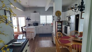 A modern kitchen with white cabinets, a central island, and a dining area with wooden chairs and a table. - Soundfront home
3 Bedrooms
3 Bathrooms (Atlantic)