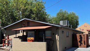 A small, single-story building with a red awning, a brick entrance, and a small porch area with a planter. - Cowboy Cottage in Historic Downtown Prescott. Go to Whiskey Row! (Prescott)