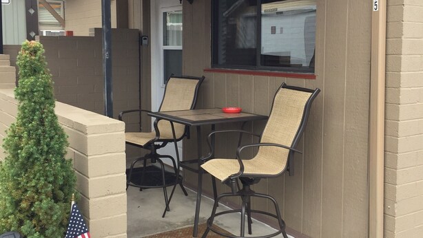 An outdoor seating area with two tables and four chairs, a small American flag, and a potted plant. - Cowboy Cottage in Historic Downtown Prescott. Go to Whiskey Row! (Prescott)