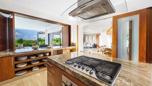 A modern kitchen with a gas stove, granite countertops, and wooden cabinetry.