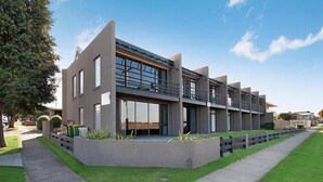 Een modern meerlaags gebouw met grote ramen en een plat dak.