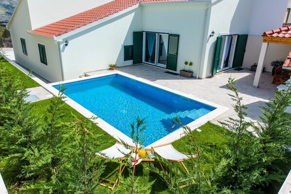 A modern house with a swimming pool, green shutters, and a patio area. - Gracefully villa Lucia **** (Mravince)