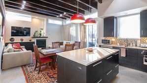 A modern kitchen with a central island, dark cabinetry, and pendant lighting.