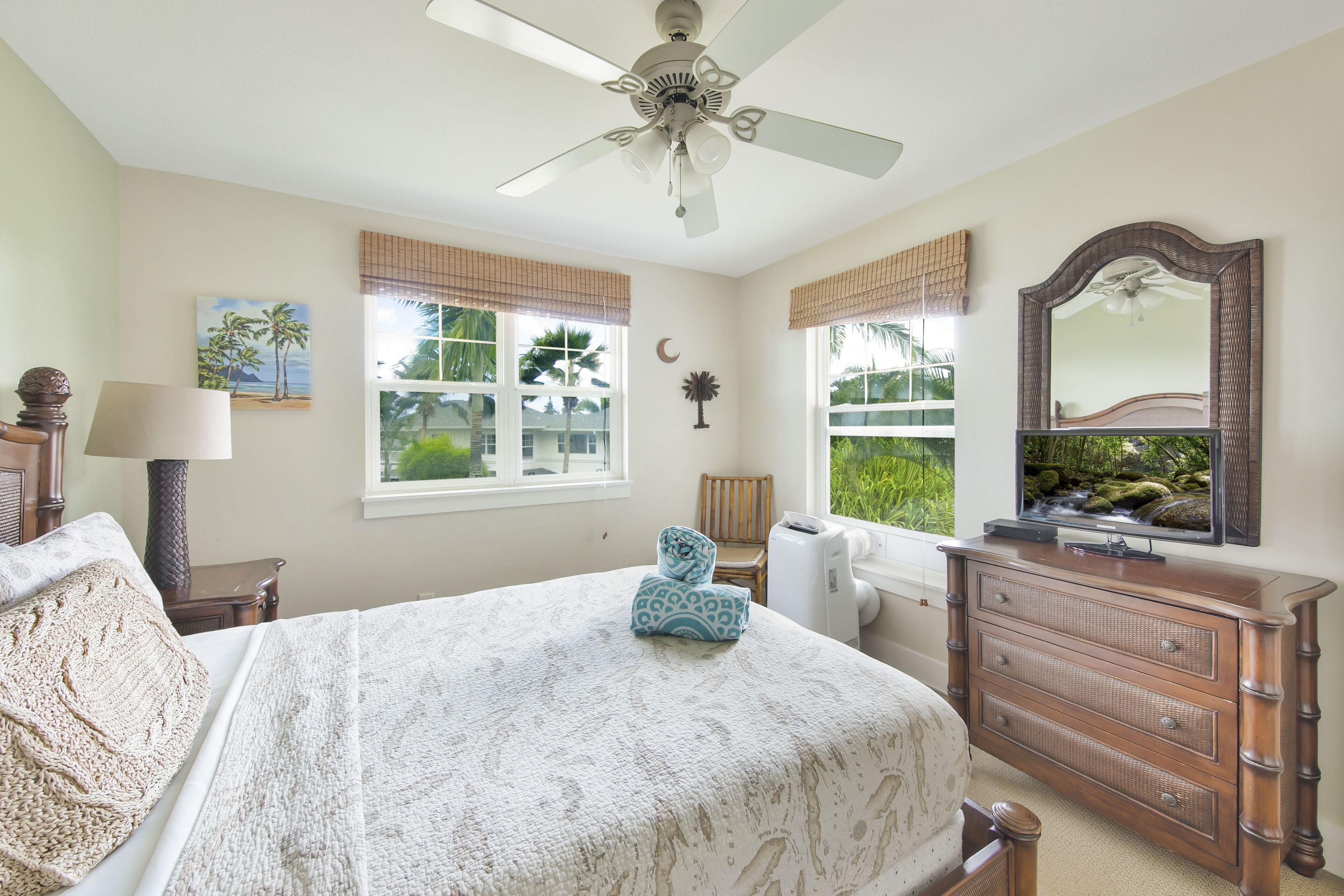 Une chambre à coucher avec un lit, une commode et un ventilateur de plafond.
