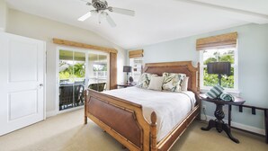 A bedroom with a wooden bed, a ceiling fan, a window with a view, and a door leading to a balcony. - Gorgeous, 3 private suites. Balcony View, Pool, Fitness Center! (Princeville)