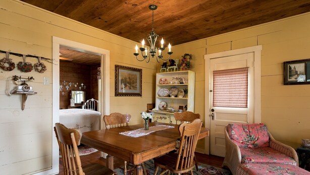 A cozy dining area with a wooden table, chairs, and a chandelier. - Broadway Cottage | Convenient Country Location (Fredericksburg)