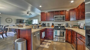 A modern kitchen with wooden cabinets, stainless steel appliances, and a central island. - Mountain-View Moab Home w/ Pool & Hot Tub Access! (Moab)