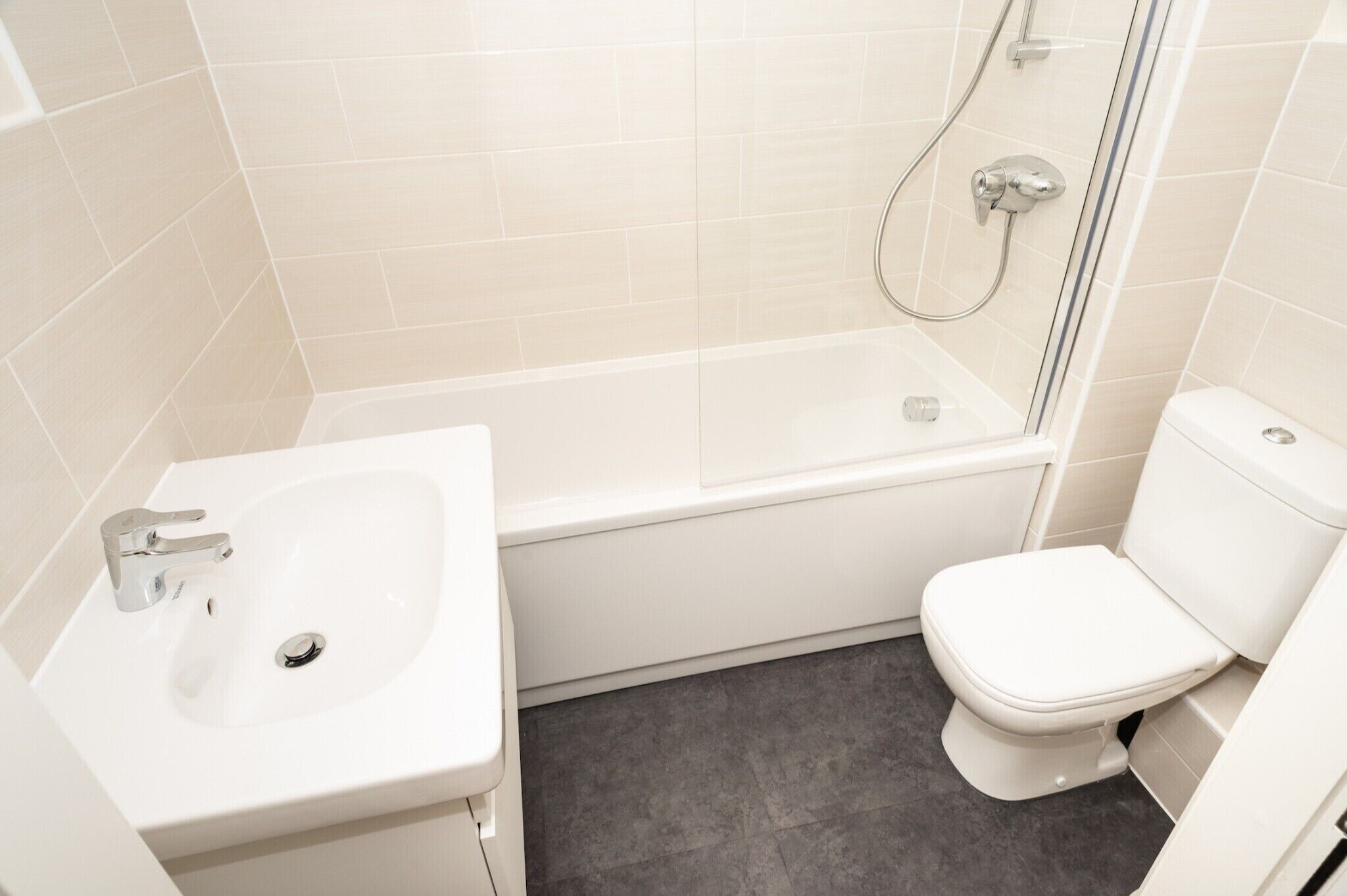 Ein Badezimmer mit einem weißen Waschbecken, einer Toilette und einer Badewanne.