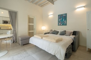 A bedroom with a bed, bedside tables, a desk, and a chair.