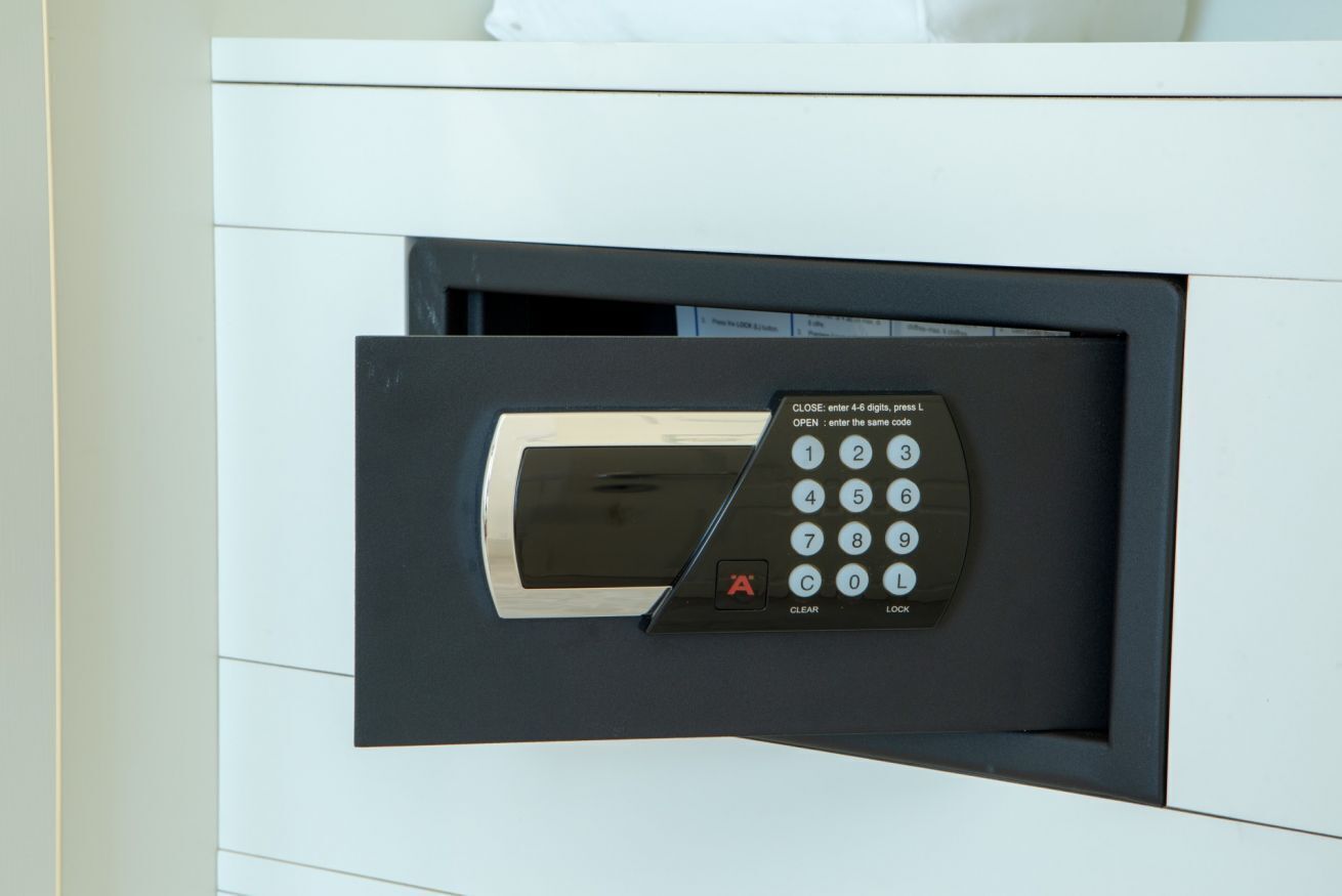 A hotel room's interior with a built-in safe and a control panel.