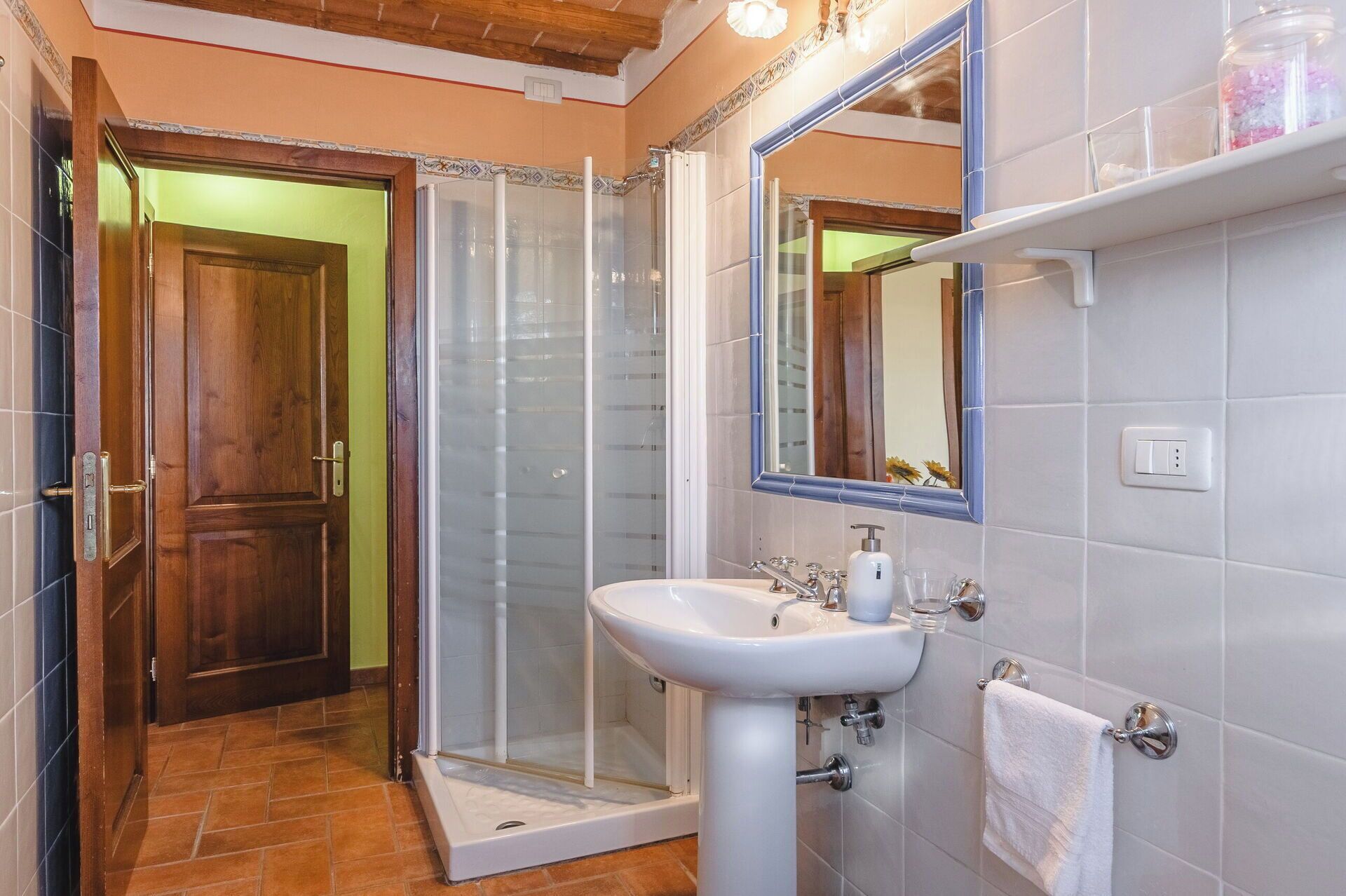 Ein Badezimmer mit Dusche, Waschbecken und Spiegel.