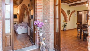 A cozy interior with a bed, a dining area, and a brick wall.