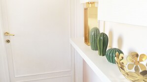 A white door with a gold handle, a white wall, and a shelf with decorative vases. - Bright, comfortable and panoramic apartment! (Roma)