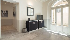 A spacious hallway with a modern kitchen area, a large arched doorway, and a view of the outside. - Carapelli 2 Fabulous apartment for up to four guests (florence)