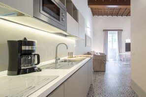 Een moderne keuken met een ingebouwde koffiezetapparaat, een magnetron en een spoelbak.