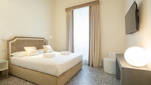A hotel room with a bed, a desk, a chair, a TV, and a window with curtains. - Carapelli 2 Fabulous apartment for up to four guests (florence)