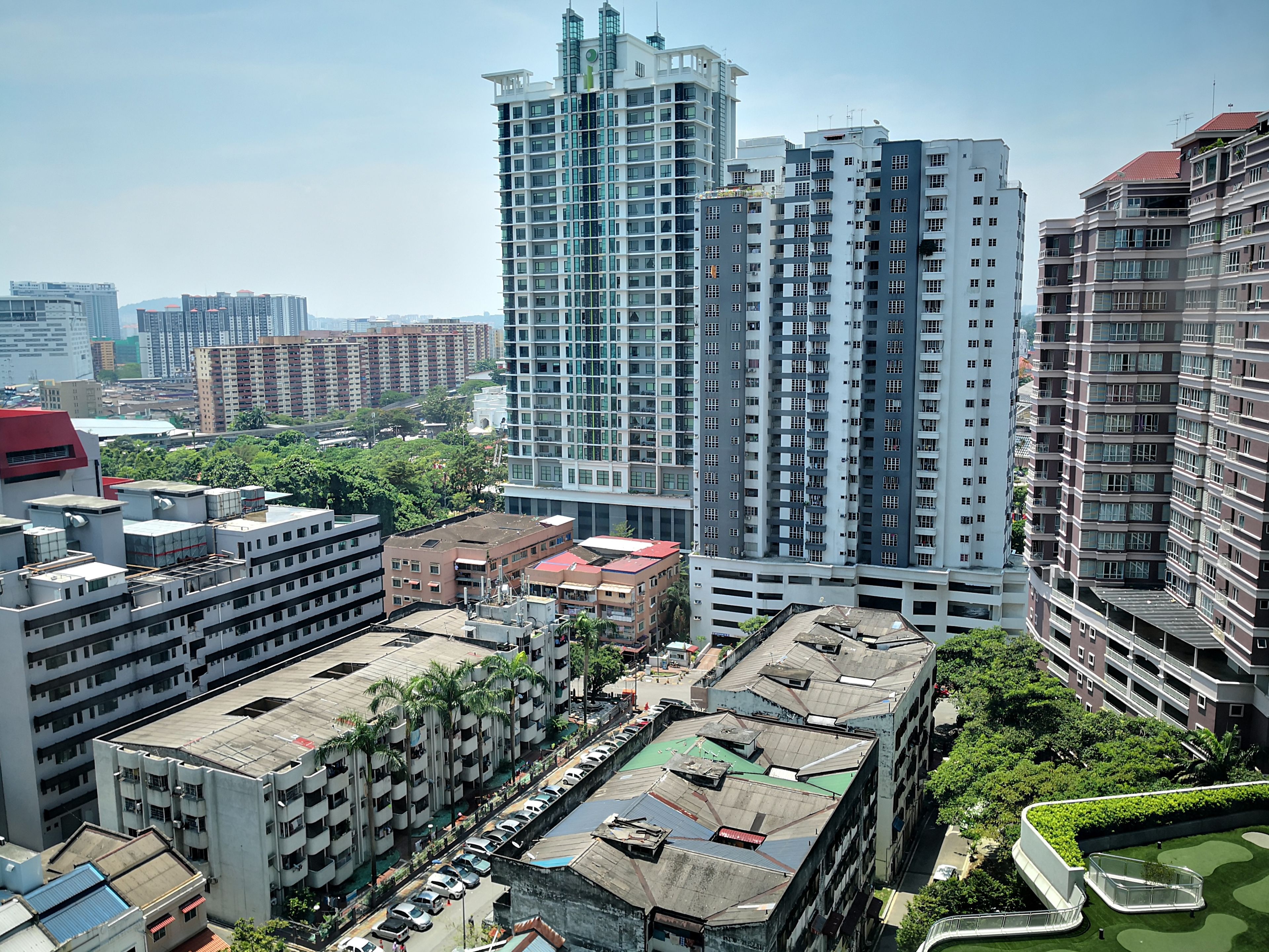 A high-rise building with multiple floors, surrounded by other buildings and greenery.