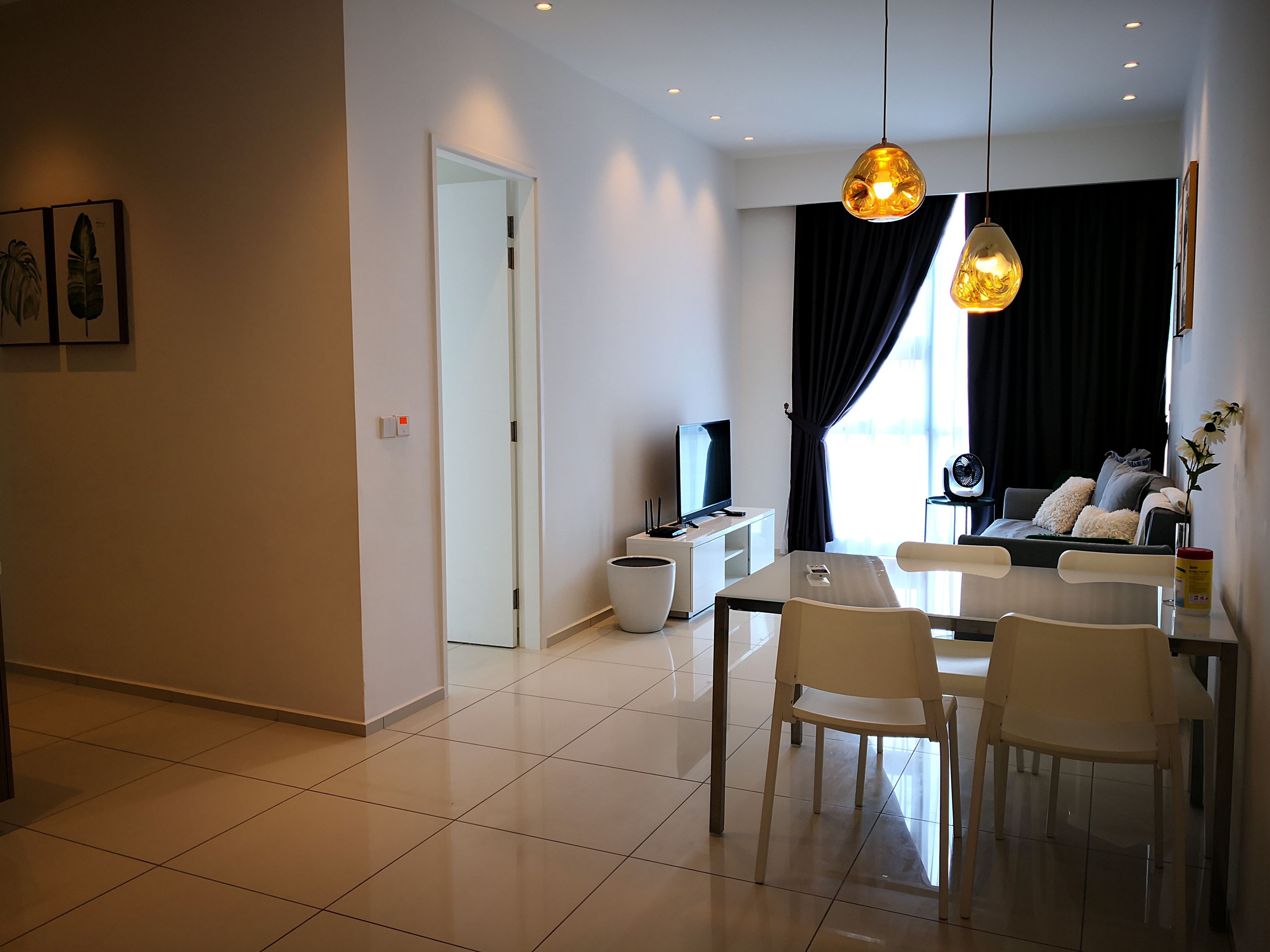Una sala de estar moderna con comedor, televisor y ventilador.