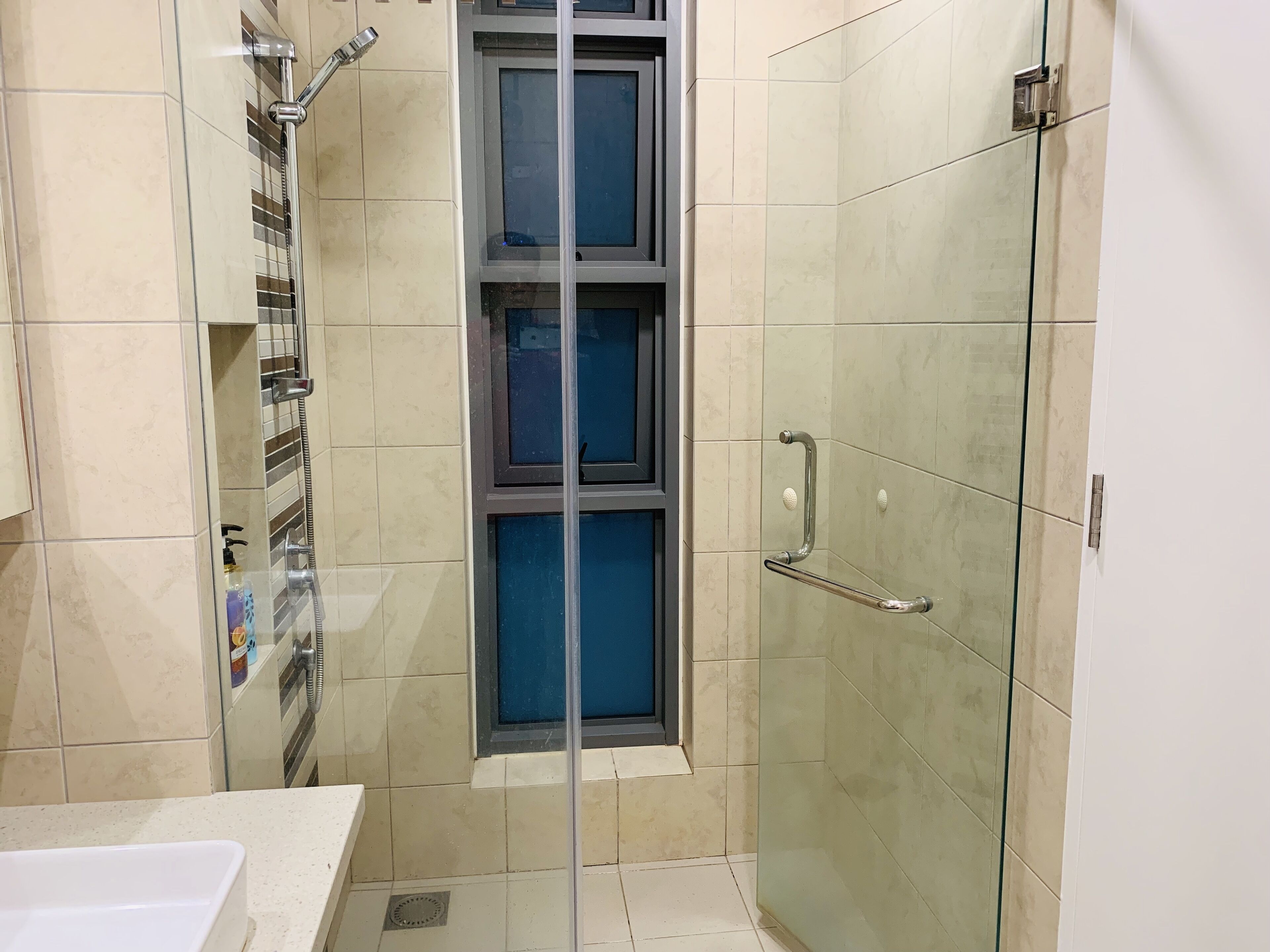 A modern bathroom with a glass shower enclosure, a sink, and a toilet.